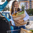 Woman carrying groceries while talking on the phone, representing independent living skills taught in the Achieve Life Skills curriculum by Education Associates.
