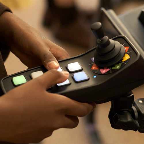 Person using CMPSR accessible music controller with joystick and buttons